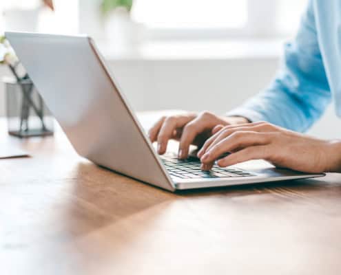 Hands of young contemporary office manager over laptop keypad during work