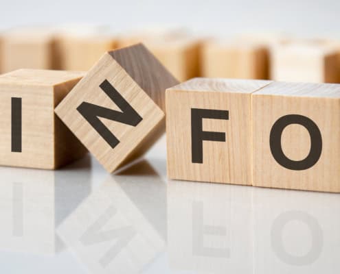 four wooden blocks with the letters info on the bright surface of a gray table, business concept